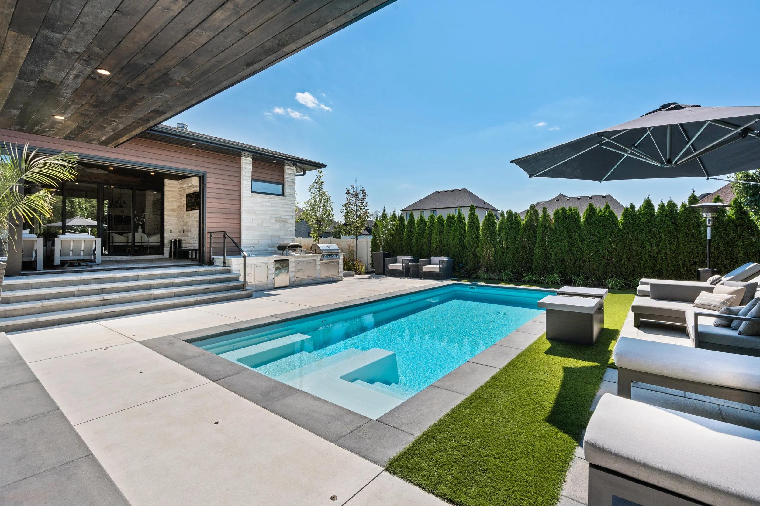 Luxury resort-style backyard with a modern swimming pool and landscaped outdoor living area